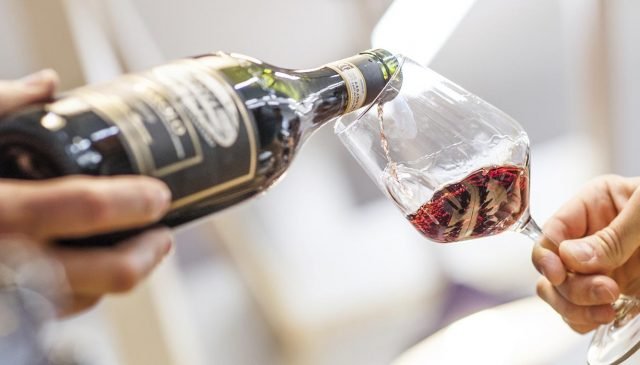 una bottiglia versa del vino a Vinum