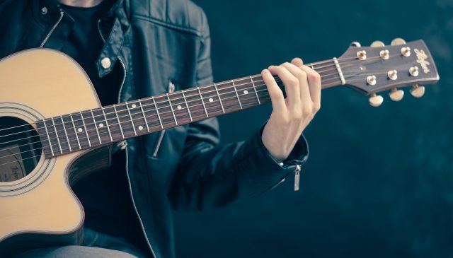 un ragazzo suona la chitarra per una lezione di musica