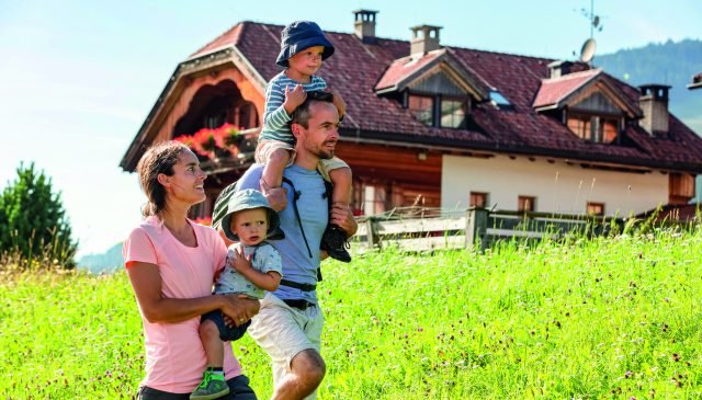 una famiglia su un prato di un maso Gallo Rosso in alto Adige
