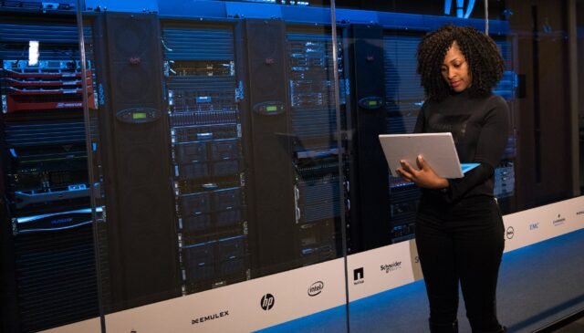 software engineer standing beside server racks