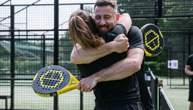 pair of tennis players hugging on the court