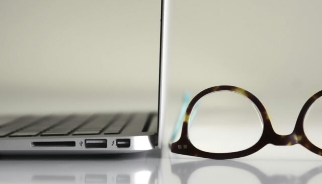 black framed eyeglasses beside laptop computer