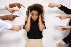 people pointing fingers at a stressed woman