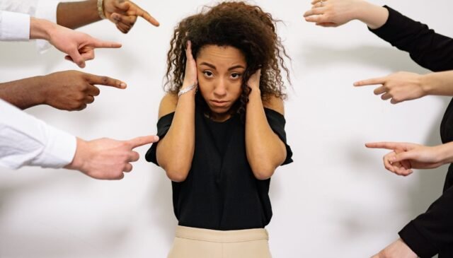 people pointing fingers at a stressed woman