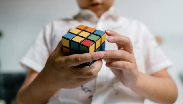 close up photo of a child solving a rubik s cube