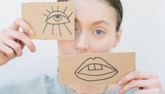 woman holding cardboard pieces with drawings
