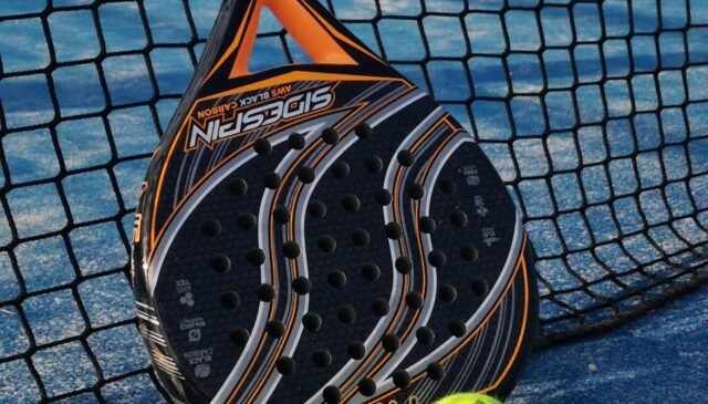 padel racket and bright balls on tennis court