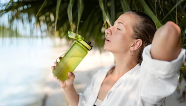 una donna si gode le vacanze estive bevendo una bevanda energetica