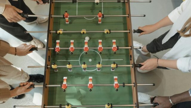 group of friends playing foosball