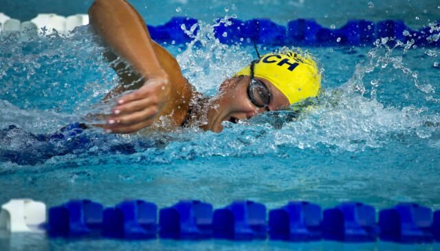 person wearing yellow swimming cap on swimming pool