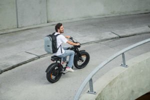 Un ragazzo in biucicletta con lo Zaino Airback grigio