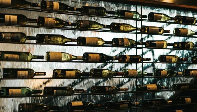 bottles of wine lying on shelves in wine store