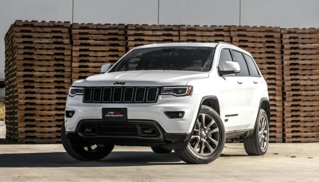 white jeep cherokee suv near stacked brown pallet boards