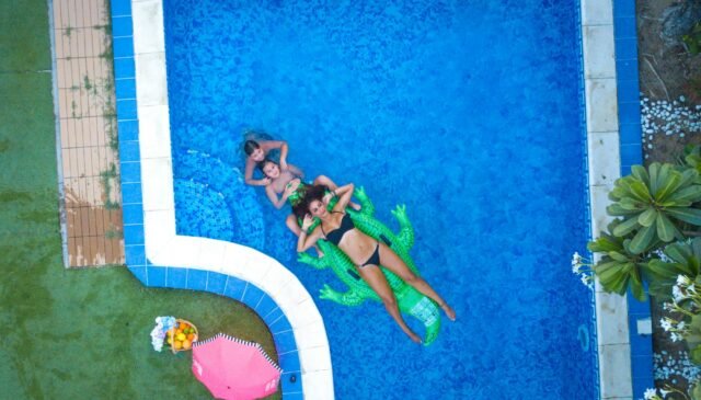 aerial photography of three people swimming