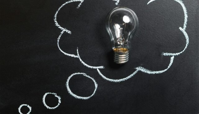 clear light bulb placed on chalkboard