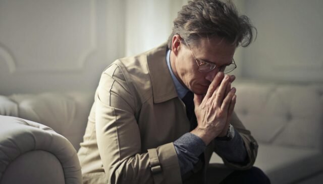 sad mature businessman thinking about problems in living room