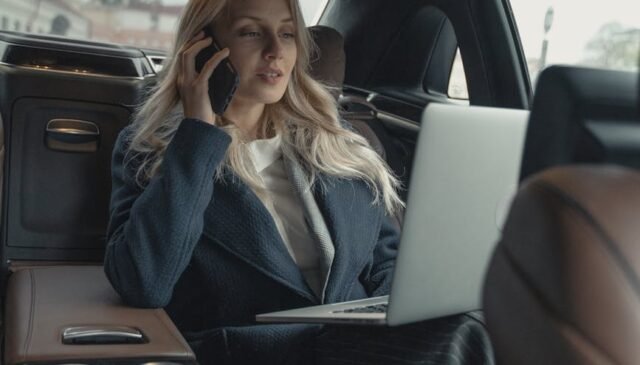 woman in gray business suit sitting in a luxurious car