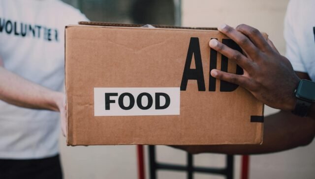 people handing over a brown box with label