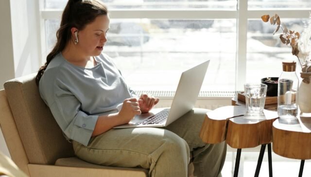 girl sitting on a couch using a laptop