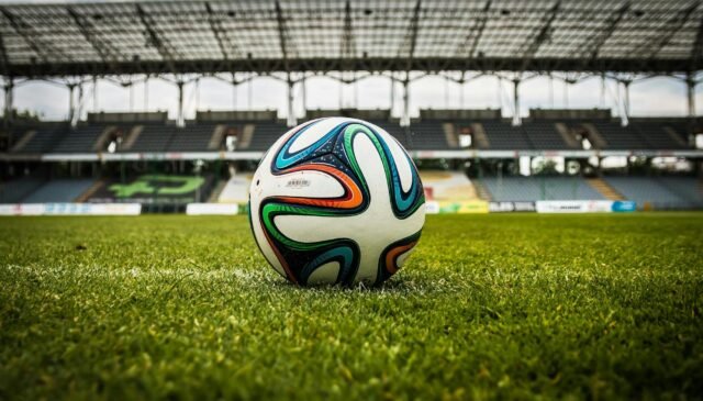 multicolored soccer ball on green field