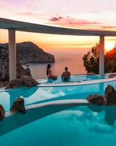 a couple in swimming pool while looking at the view