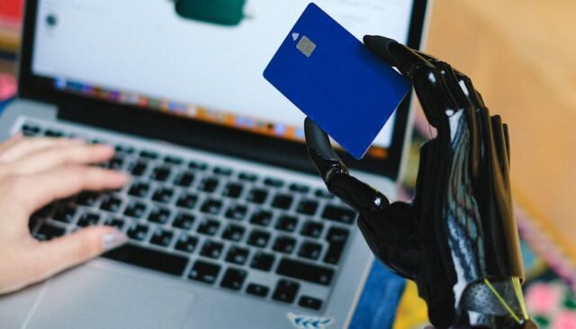 person holding blue card on macbook pro