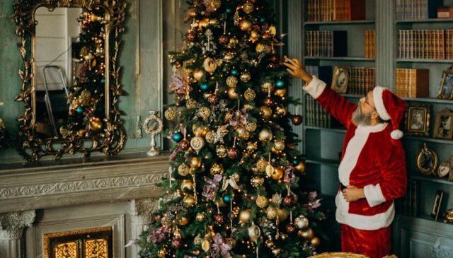 man standing beside christmas tree