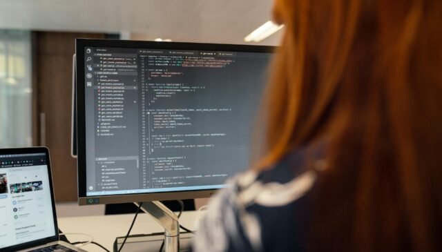 female software engineer coding on computer
