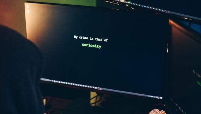 unrecognizable male cyber spy hacking computer system in darkness