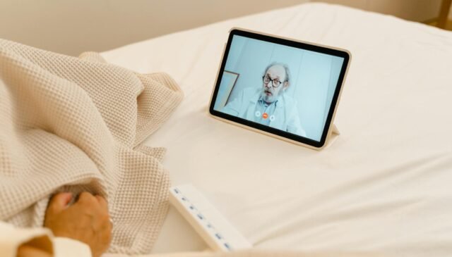 white digital tablet on the bed