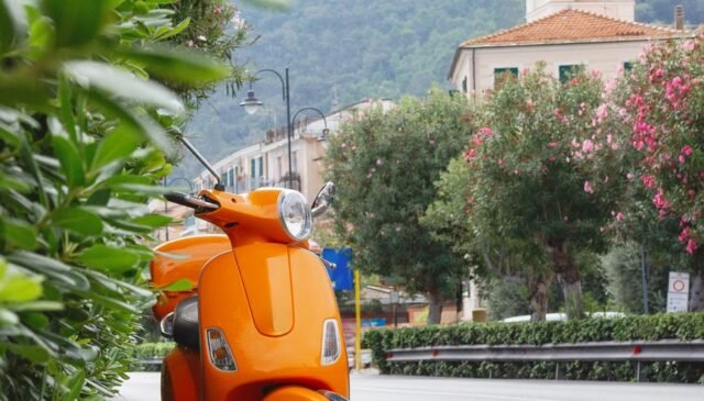 bright orange vespa in noli liguria